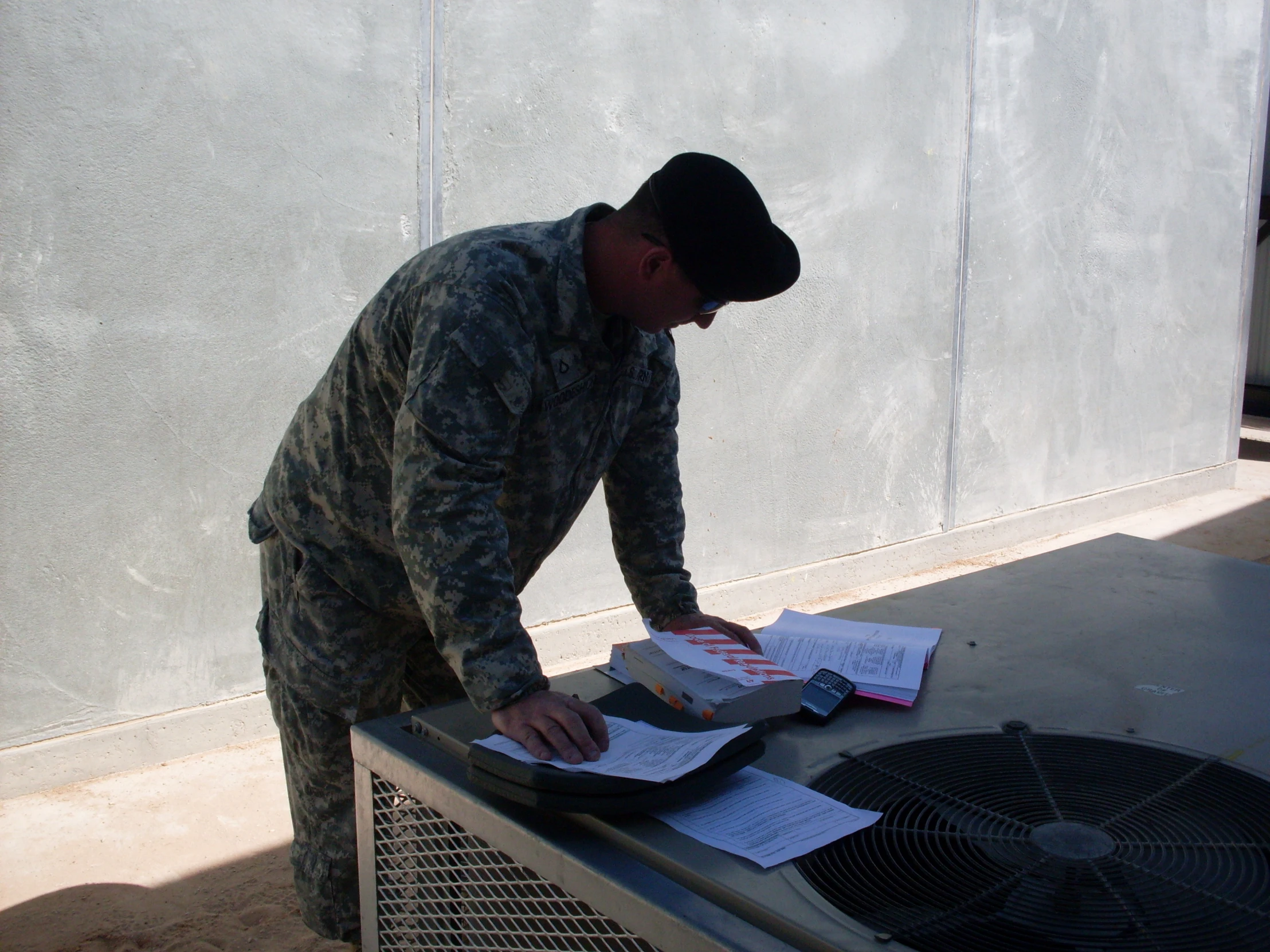 a man in army fatigues is holding a piece of paper