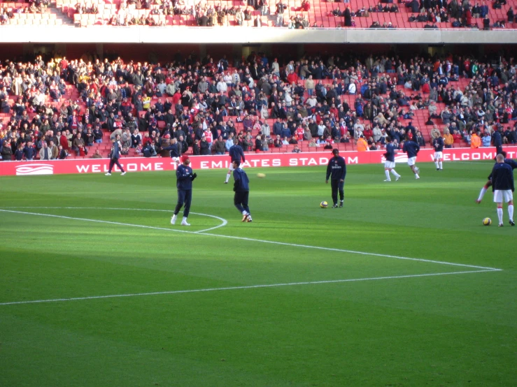 soccer players practicing in front of an empty stadium