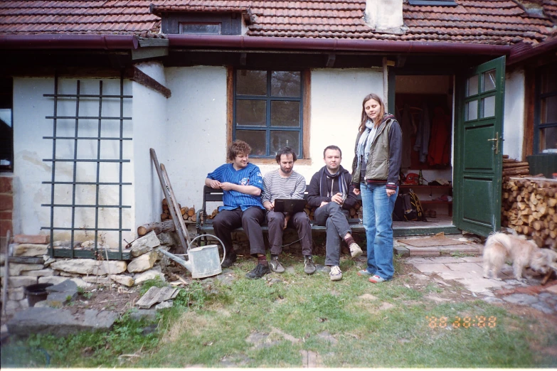 a group of people sitting outside of a home