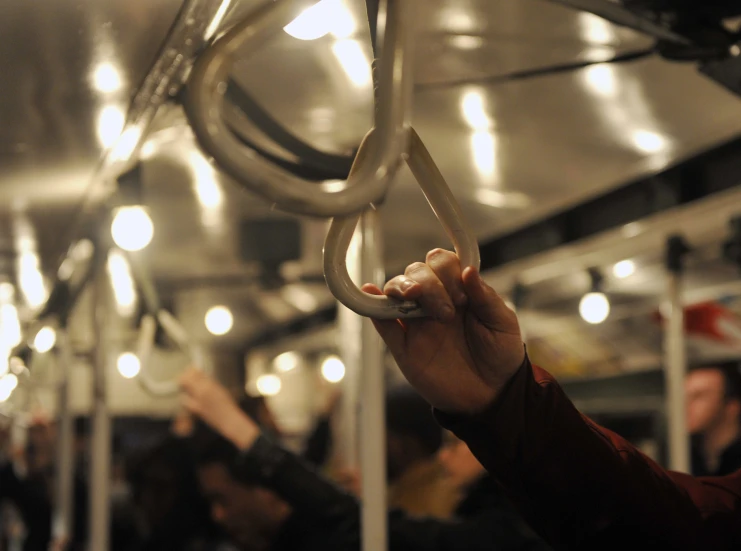 a person holds up an item in the middle of a bus