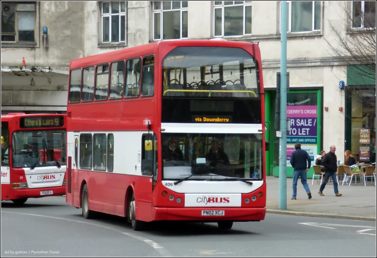 a red and white bus and some people on a street