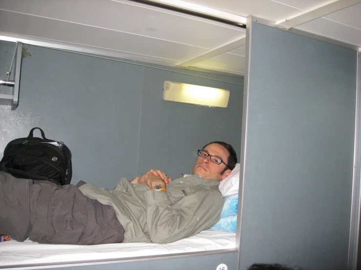 a man in glasses sleeping on a bunk