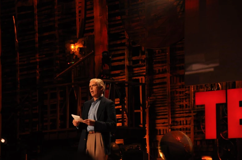 a man is standing and talking on stage