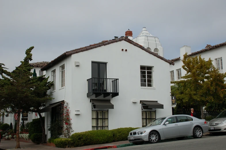 a house sitting next to a car in front of a tall building