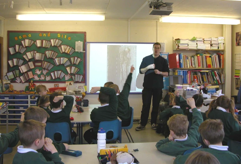 two male students in a classroom with a teacher