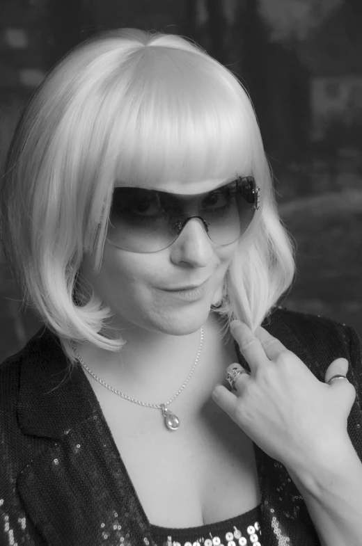 a blonde woman with sunglasses and a necklace