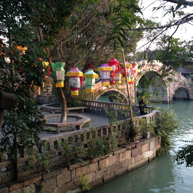 a bridge with colorful umbrellas suspended over it