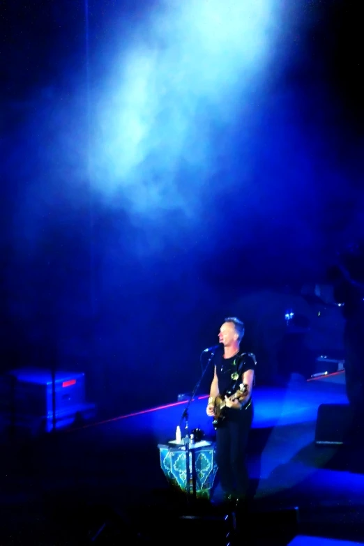 man standing on a stage with microphone in front of him