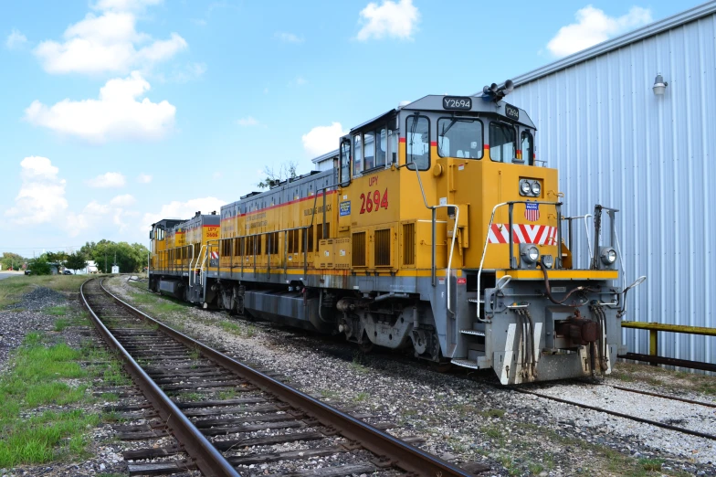 a yellow train sitting on top of the tracks