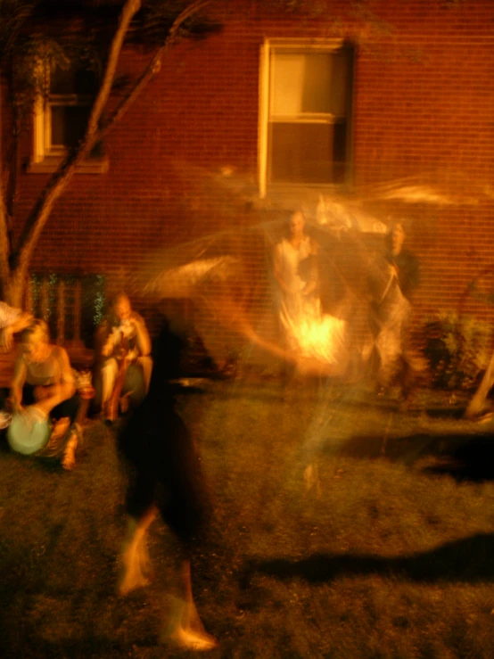 a blurry image of people playing in front of a brick building