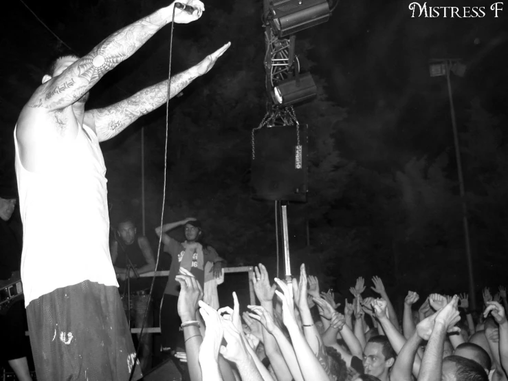 a man performing on stage as a crowd watches