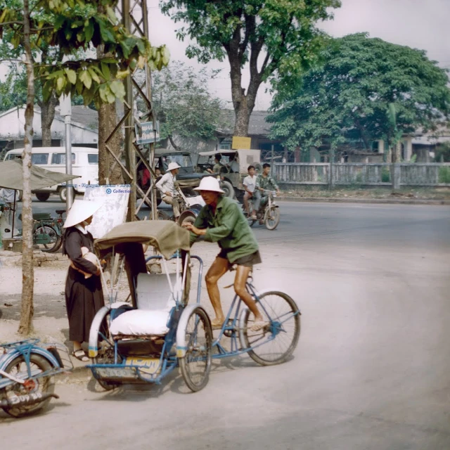 a woman on a small tricycle parked in front of a man on a bike