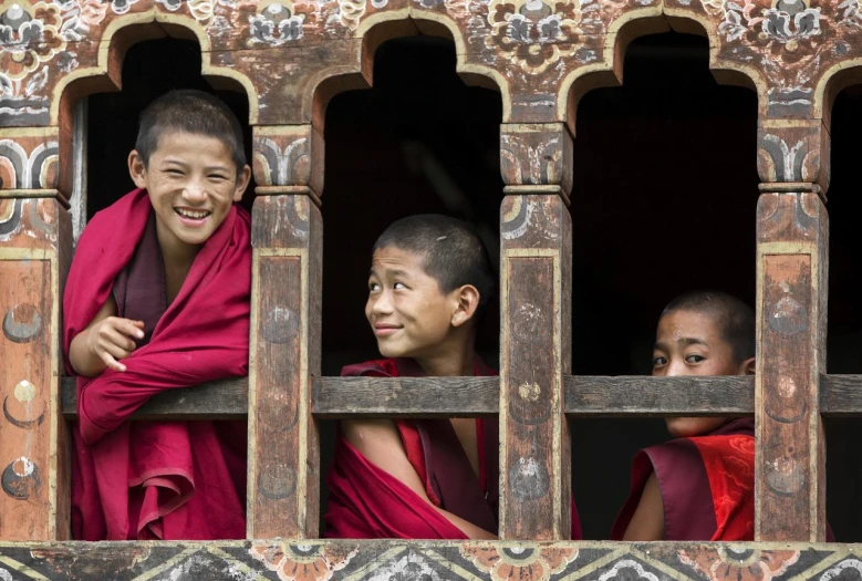 two monks smiling while looking out the window