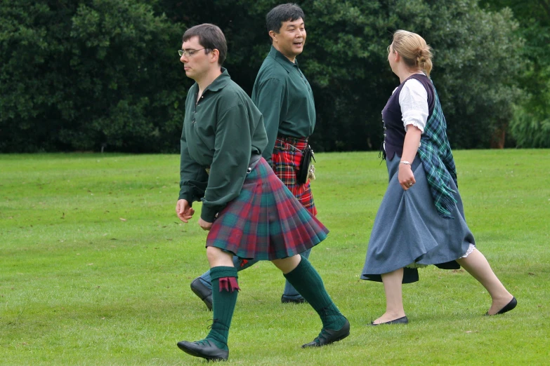 people in costumes walk around in a park