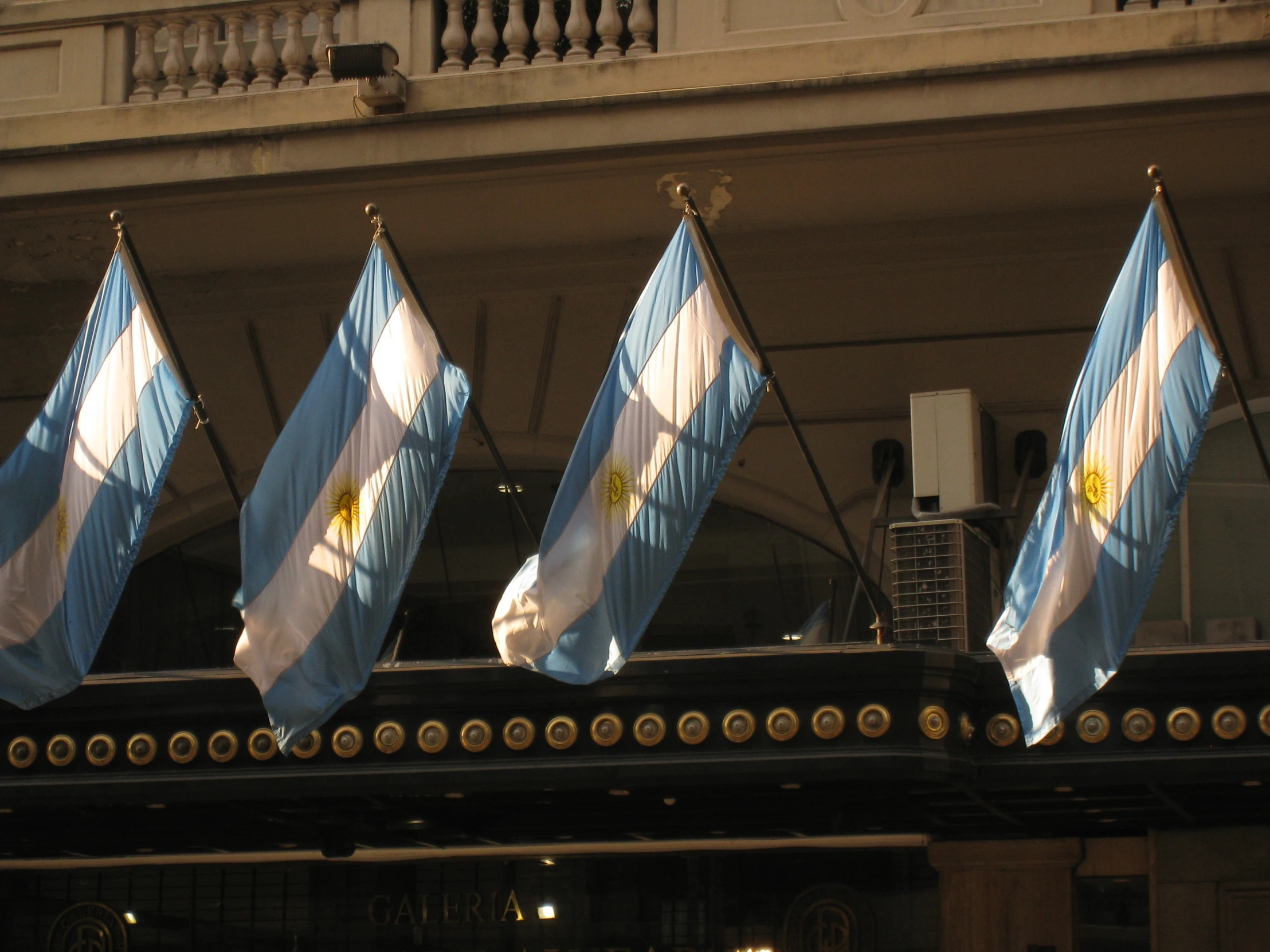 five flags are in a row attached to a building