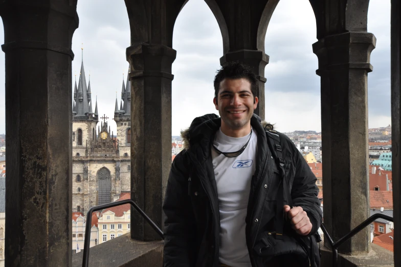 man with beard smiles with cityscape in background