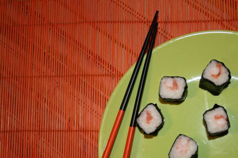 chop sticks and shrimp rolls are on a plate