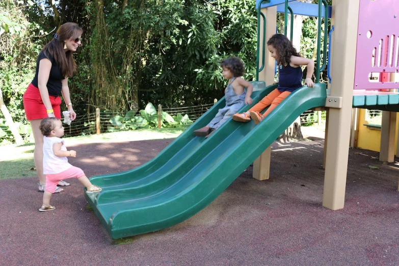 three young children on a colorful play set