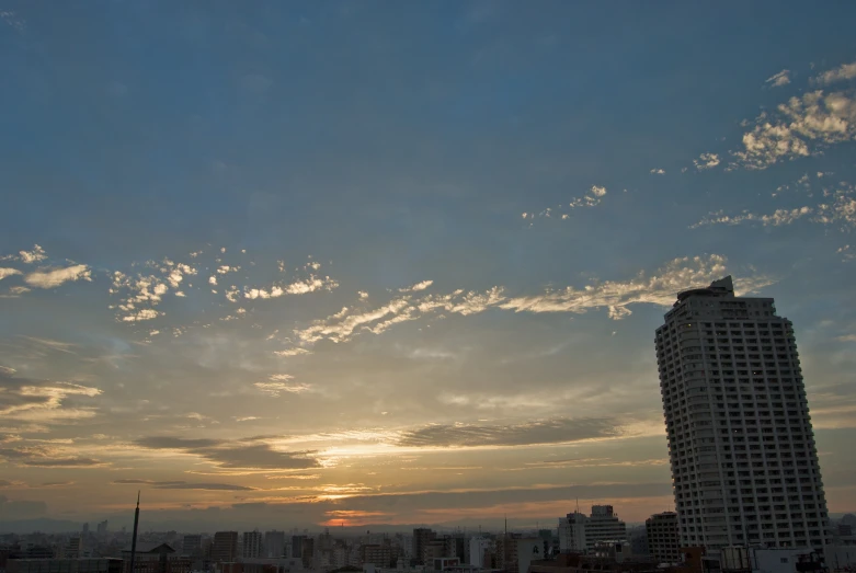 the sun rises over a city with tall buildings