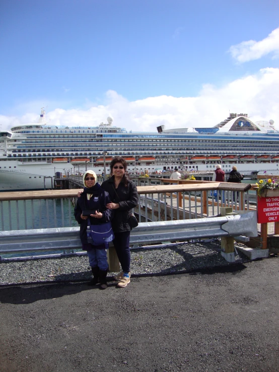 two women standing in front of cruise liners in a harbor