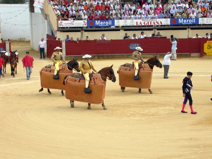 some people and horses on an arena playing