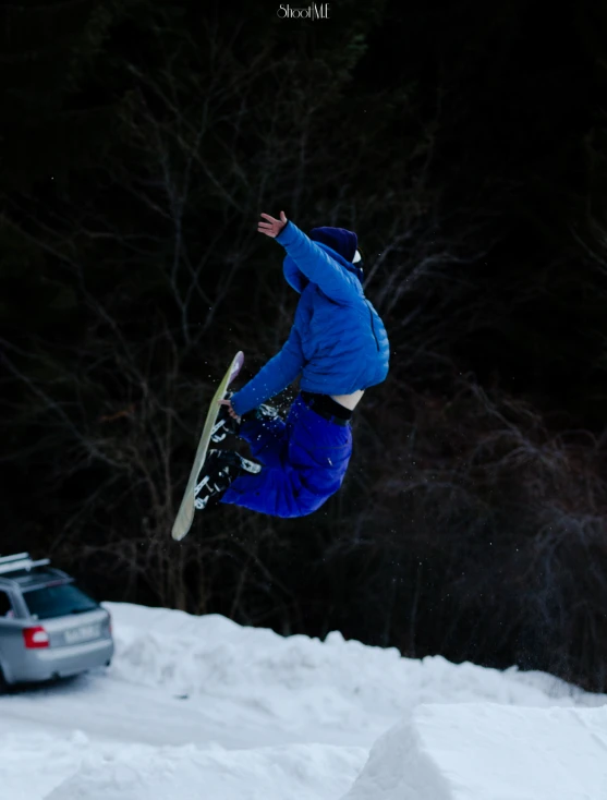 a man flying through the air on top of a snowboard