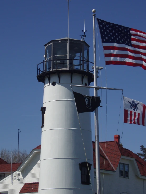 an american flag flying from the top of a tall lighthouse