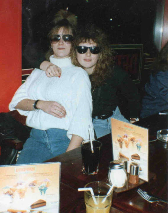 two women sitting next to each other at a table