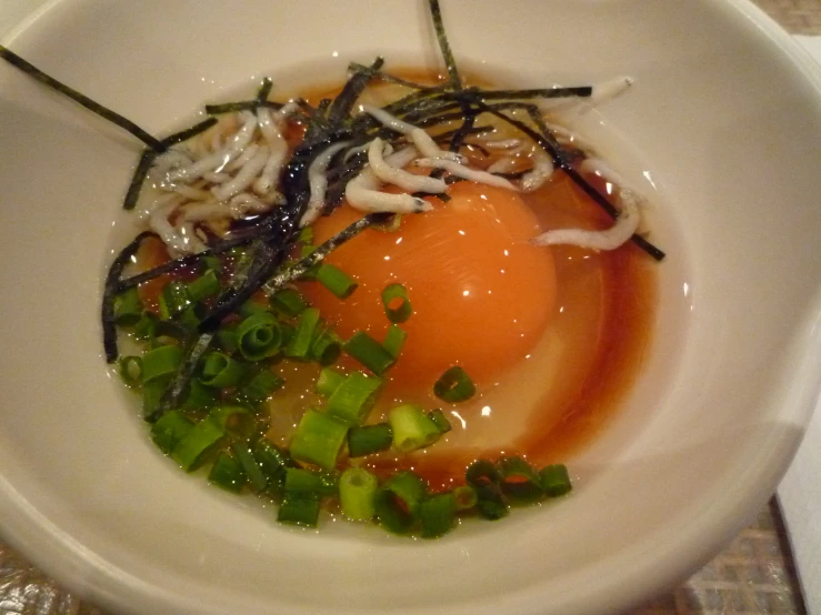 a bowl of food on a table with an egg