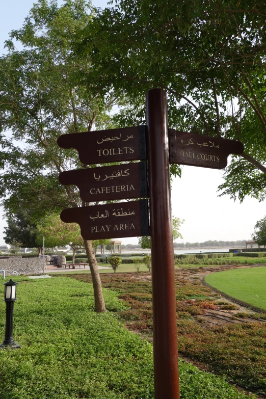 street signs with directions on post in a park