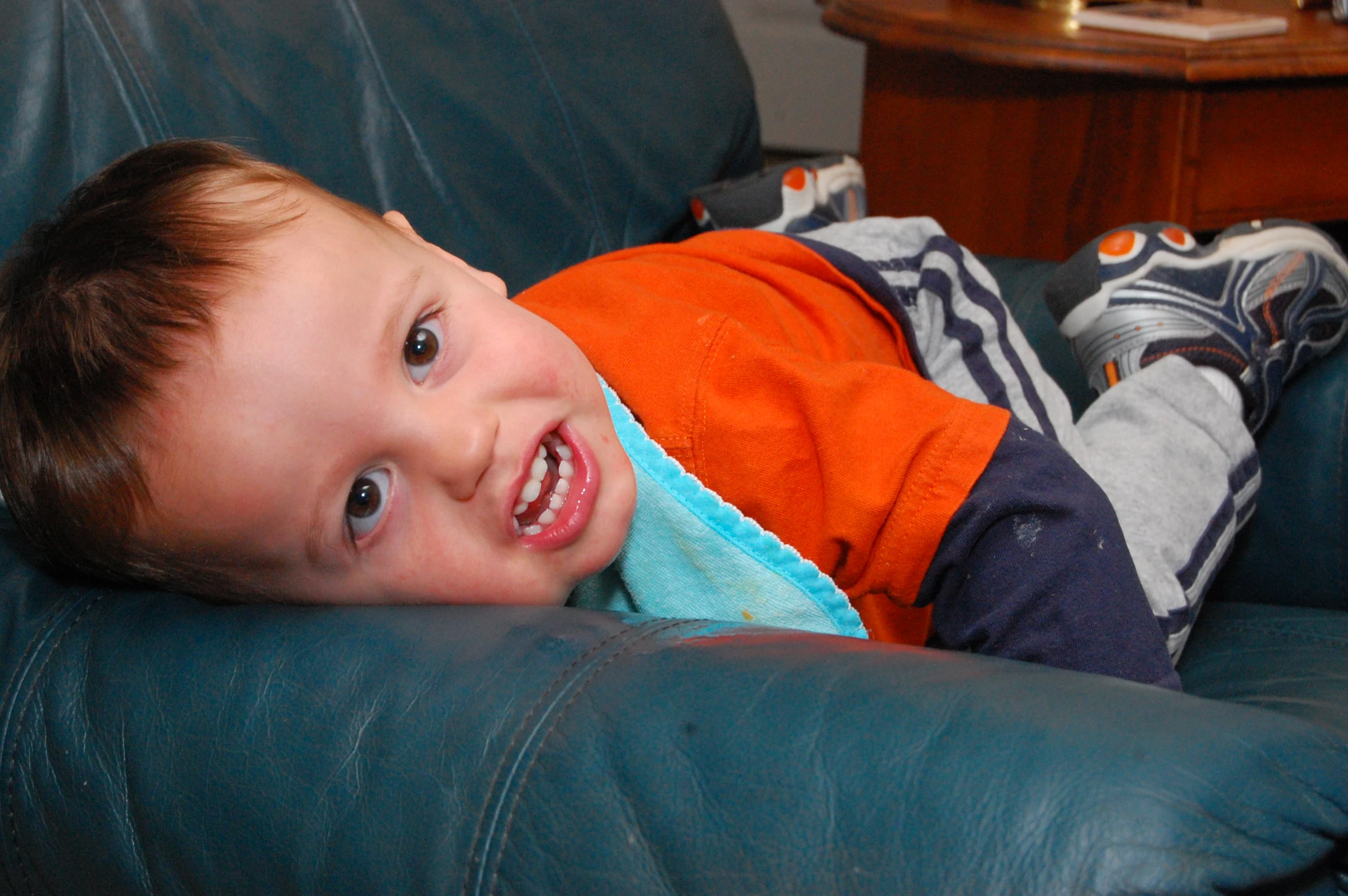 a  on a couch with a blanket covering his face