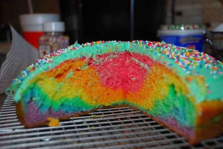 a very colorful cake is sitting on the grill