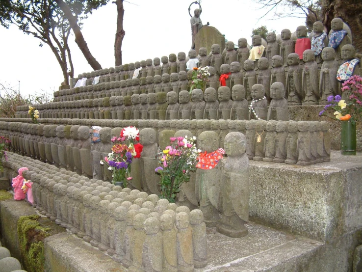 a stone garden bench with many flowers in pots