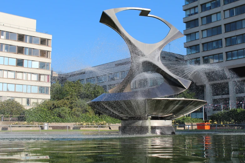 a statue in front of a large building near a lake