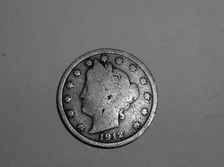 the coin has stars on it and is sitting in a grey background