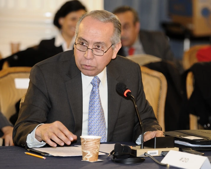 a man sitting in front of a microphone while talking