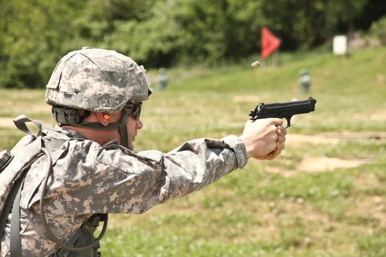 the soldier in camouflage is shooting a plastic gun