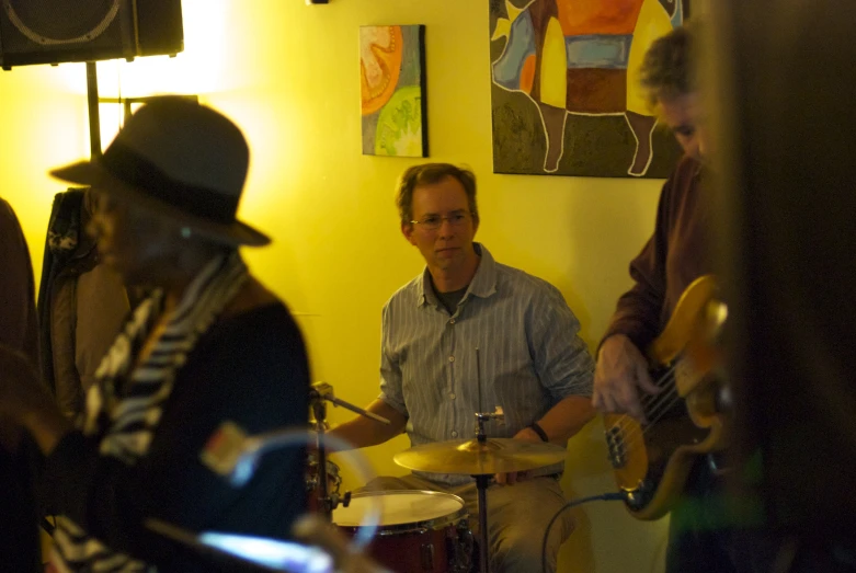 three musicians playing music in a small room