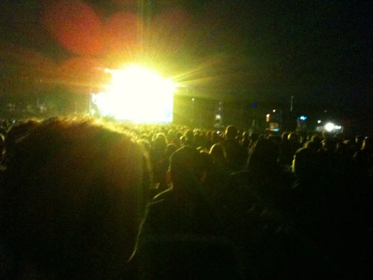 a crowd is in the dark at a concert