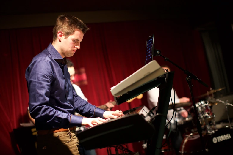 two men playing electronic musical instruments with microphones and sound equipment