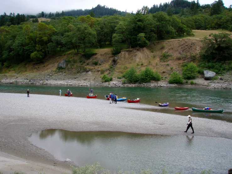 a beach area with several boats and people in the water