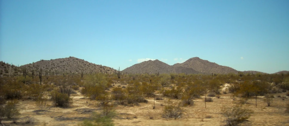 an arid desert landscape with mountains in the background