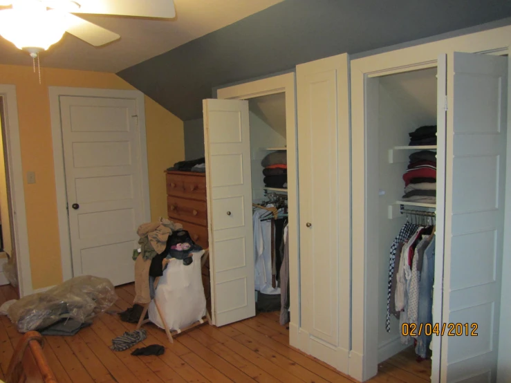 a room with a closet, two closet doors, and a chair