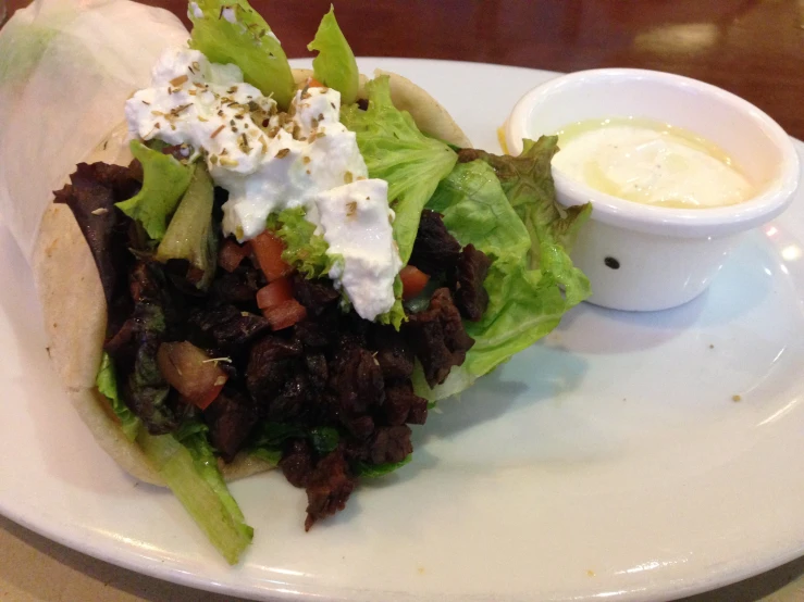 a salad with dressing on a white plate