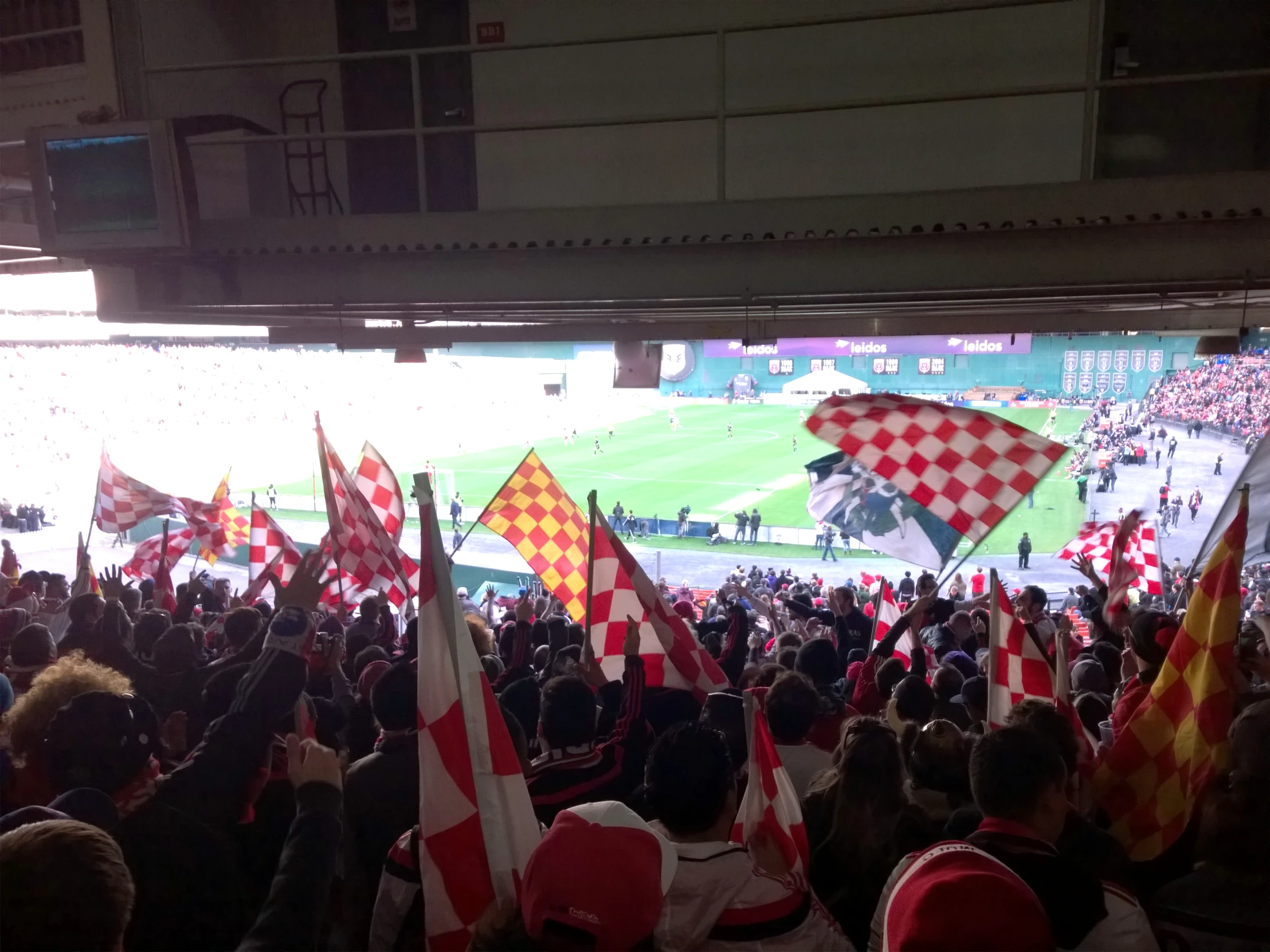 many people with checkered flags on and facing the stadium