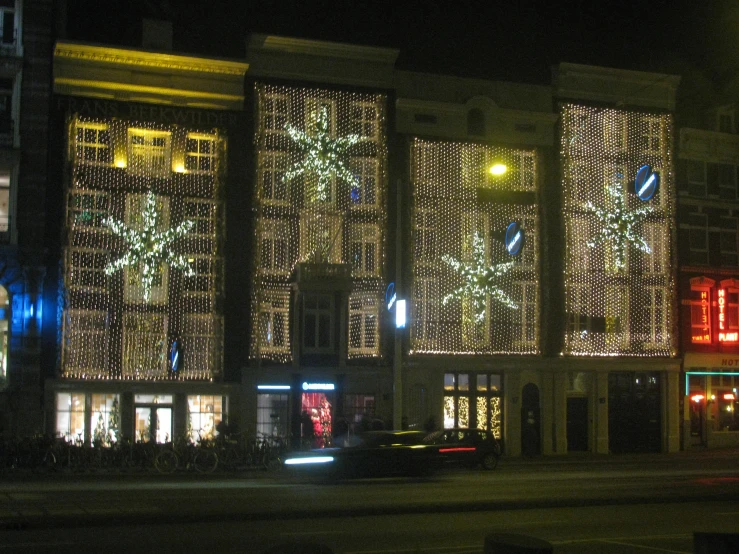 christmas lights adorn an old fashion building at night