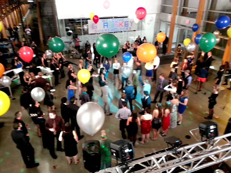 group of people gathered together and many of the balloons are multicolored