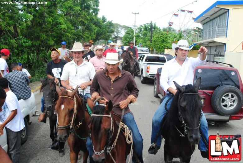 a large group of people riding horses down the road
