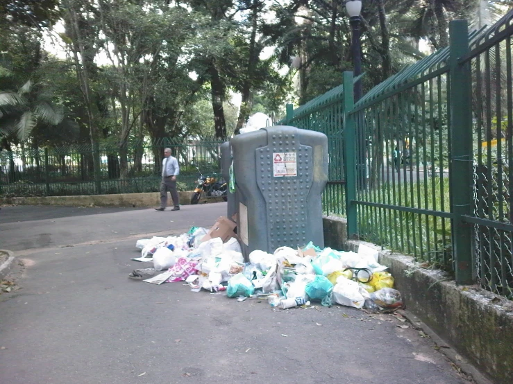 a pile of bags, flowers and litter near the road