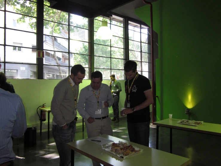 three men standing next to each other near a table